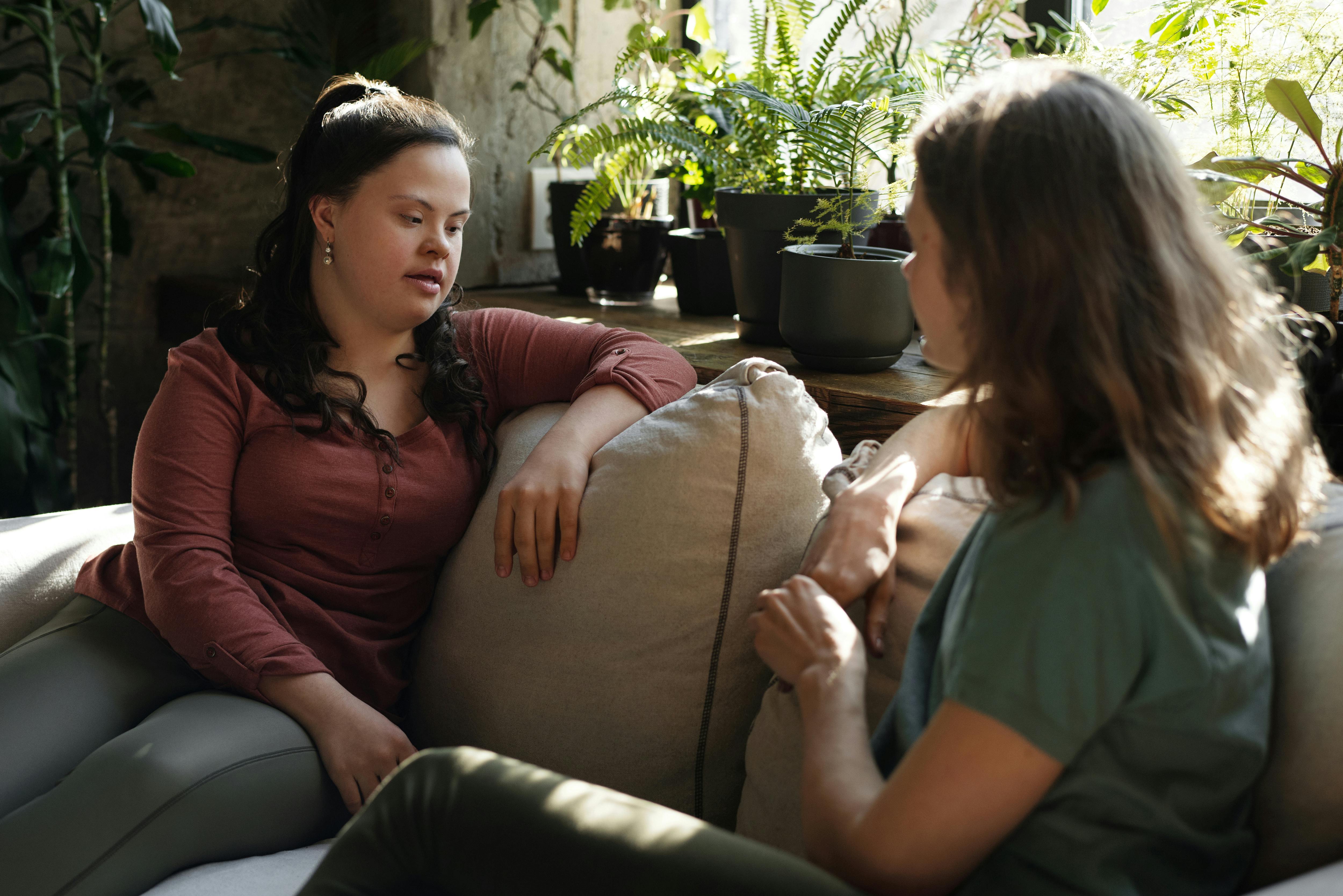 two people sat on a sofa chatting