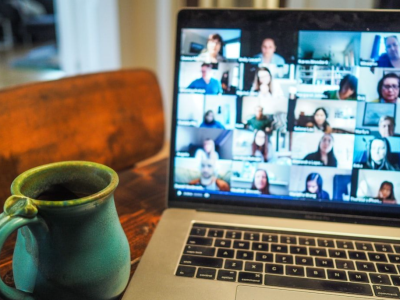 Laptop on a table showing an online webinar taking place.